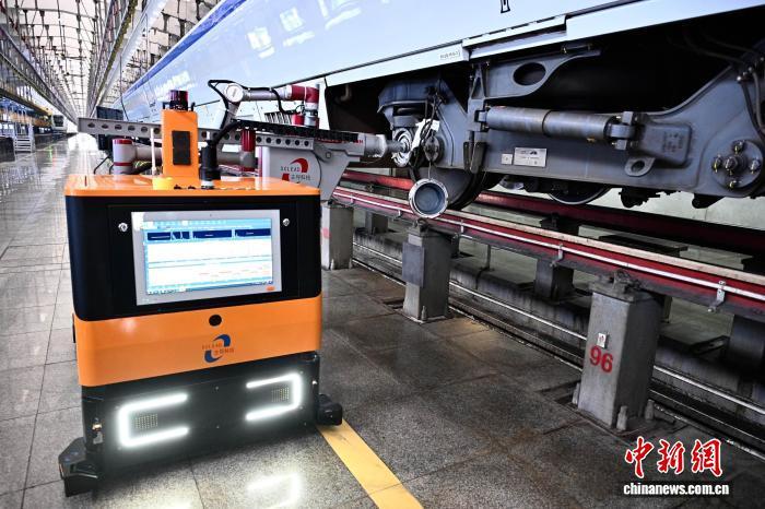 3月25日,位于福建省福州市的福州南动车所内,智能探伤机器人正对动车组进行检测。智能探伤机器人能实现全天候、无人化整列探伤。中新社记者 张斌 摄