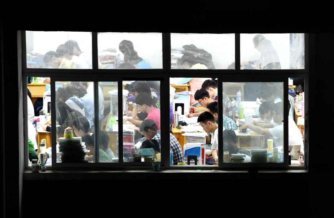 河南一所中学的学生们在教室里挑灯夜读,备战高考。