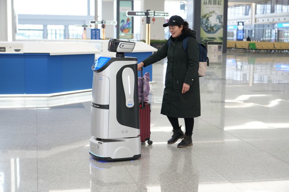 2月2日,旅客正在和福州南站的智能服务机器人“阿福”互动。(江曲 摄)