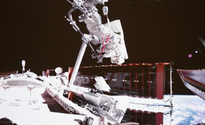 这是2025年5月22日在北京航天飞行控制中心屏幕上拍摄的神舟二十号航天员陈冬在空间站组合体舱外工作的画面。新华社记者 厉彦辰 摄