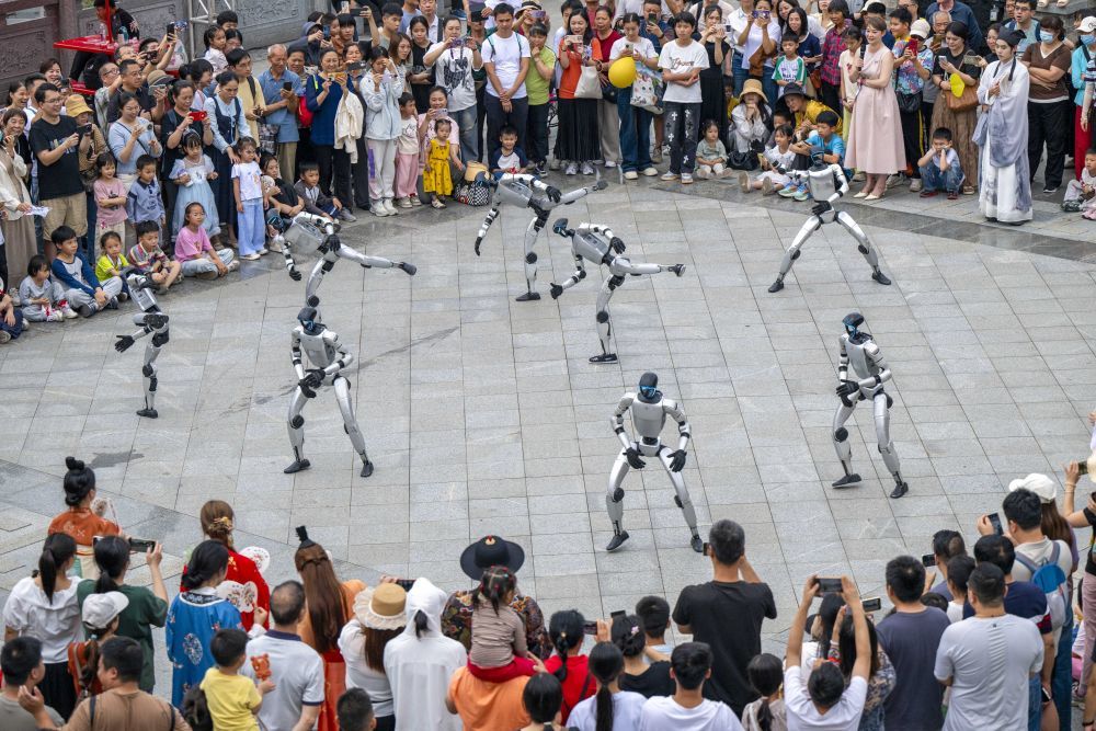 ↑ 5月2日，在广西梧州市岭南文化园，机器人为游客表演（无人机照片）。新华社发（何华文摄）