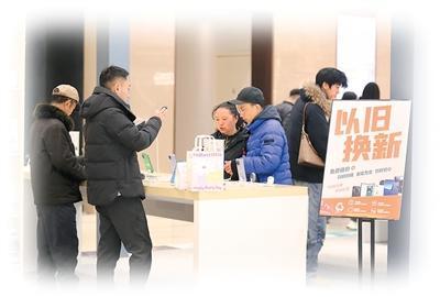 1月6日，四川省乐山市市中区一家大型商业购物中心内，消费者在挑选新款手机。李华时摄（人民图片）