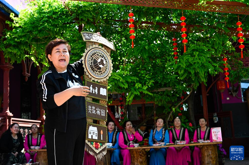 在新疆伊宁县喀拉亚尕奇乡喀拉亚尕奇村“伊犁人的奶茶会”现场，乡便民服务中心卫教妇幼岗干部热依兰&middot;艾合买提向村民讲解“好家风”（5月14日摄）。