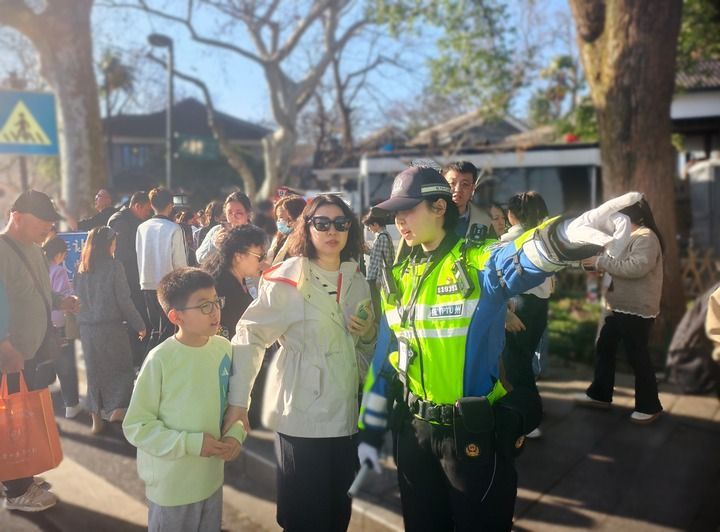 2月21日,在浙江杭州西湖景区,杭州市公安局交管支队景区大队灵隐中队民警李雨杭为行人指路。新华社发