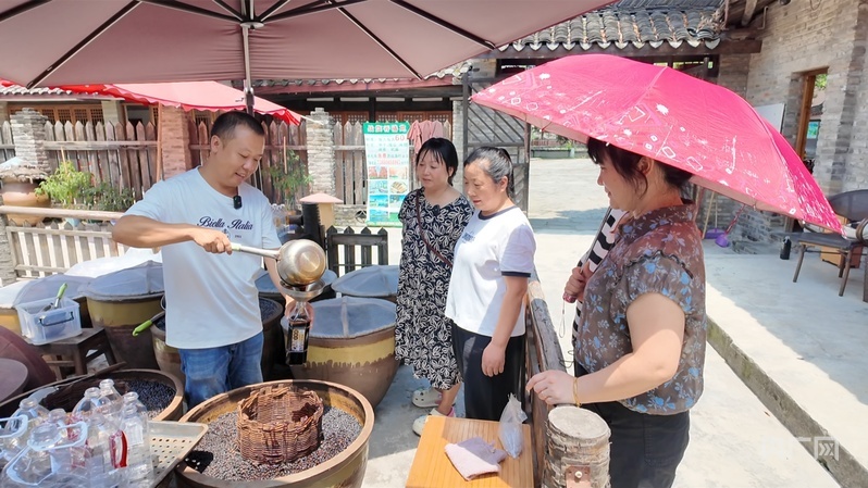 酱园坊内,刘畅正在为游客们灌装酱油(央广网记者 昌思荣 摄)