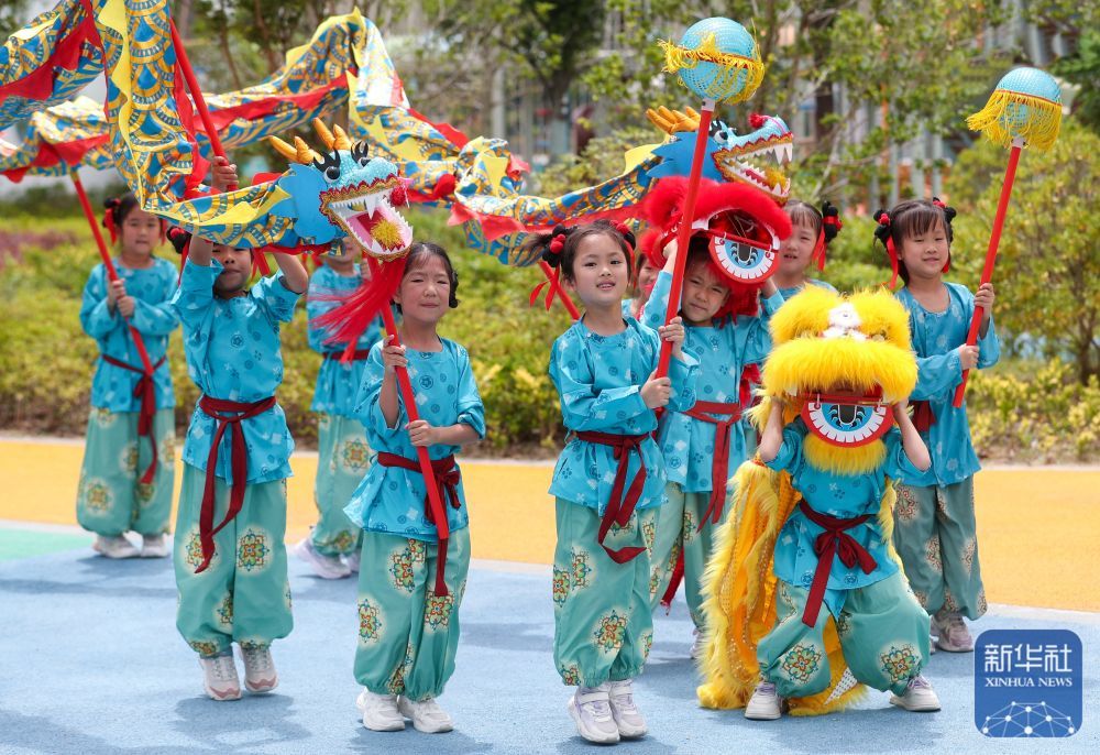↑ 6月17日,小朋友在江苏省泰州市姜堰区东桥幼儿园进行舞龙舞狮表演。新华社发(周社根摄)