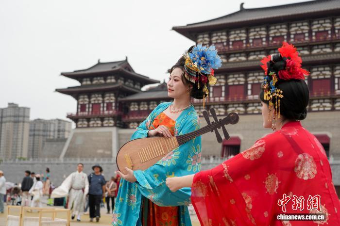 5月1日，游客身穿汉服在位于河南洛阳的隋唐洛阳城应天门遗址博物馆前拍照。　中新社记者 李超庆 摄