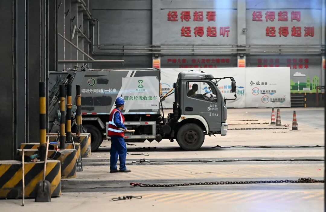 2024年6月4日,工作人员驾驶垃圾运输车往垃圾仓里倾倒垃圾/新华社记者 李然 摄