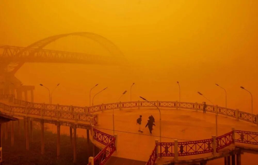 10月14日，印尼中加里曼丹省帕朗卡拉亚市卡哈扬河畔，人们穿行在红褐色的烟霾中。（图源：路透社）
