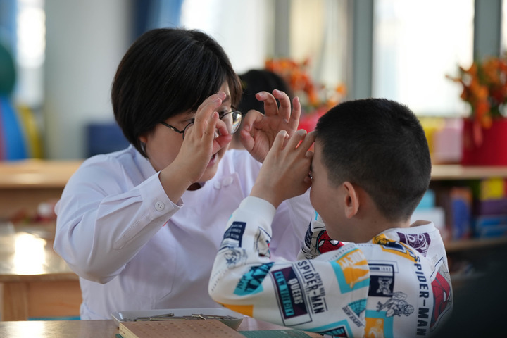 2月5日，在北京市儿童福利院，龙龙（右）在上课。新华每日电讯记者谢晗 摄