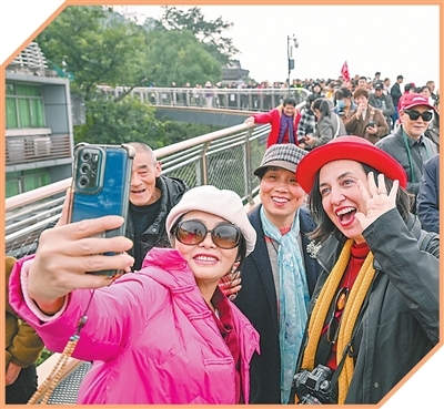 外国游客在重庆半山崖线鹅岭栈桥与市民合影。新华社记者 陈 诚摄