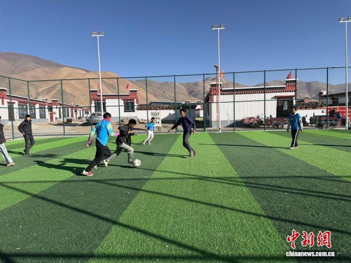 1月5日,森嘎村球场上,孩子们在踢球。中新社记者 赵朗 摄