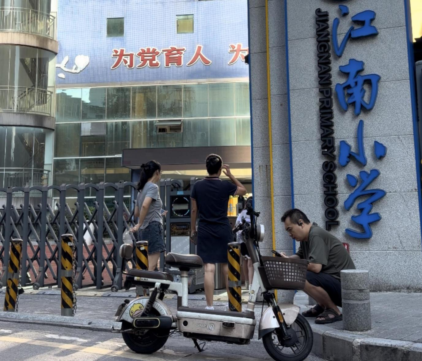 校门口接送孩子的家长们(央广网发 罗琳娅 摄)