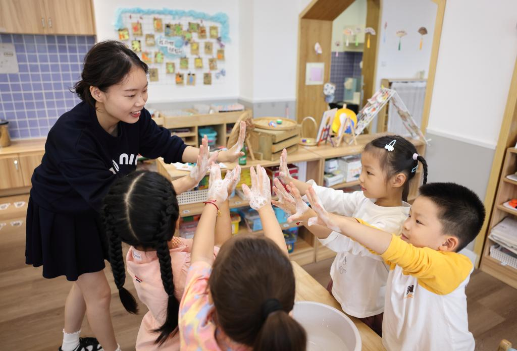 浙江诸暨市一家幼儿园的老师在指导小朋友正确洗手。新华社发(郭斌 摄)