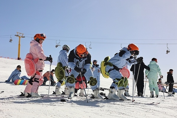 众多游客在滑雪场体验冰雪运动