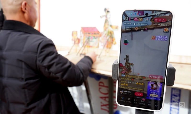 演出中陈增光通过手机进行直播（央广网记者 贾海元 摄）