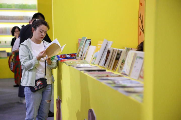 5月14日，观展者在第三届东北图书交易博览会现场阅读书籍。新华社记者 颜麟蕴摄