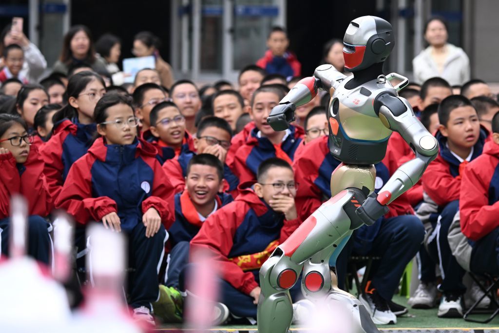 2025年10月13日,新疆生产建设兵团第一中学学生在科技节开幕式上观看智能机器人跳舞。新华社记者 王菲 摄