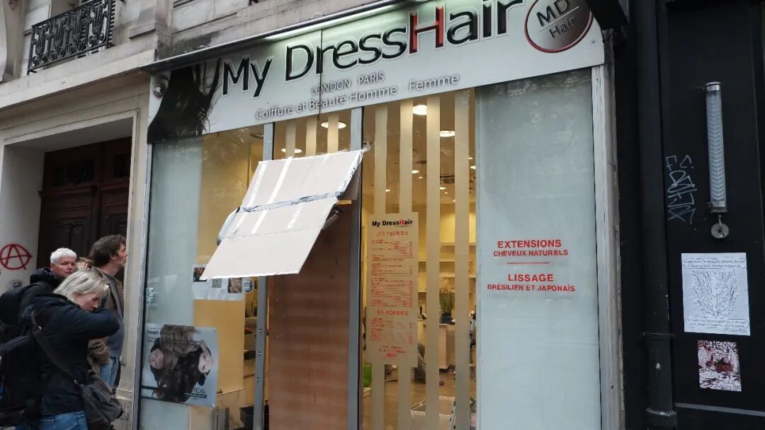 玻璃大门被砸碎、店内被洗劫一空的美发店