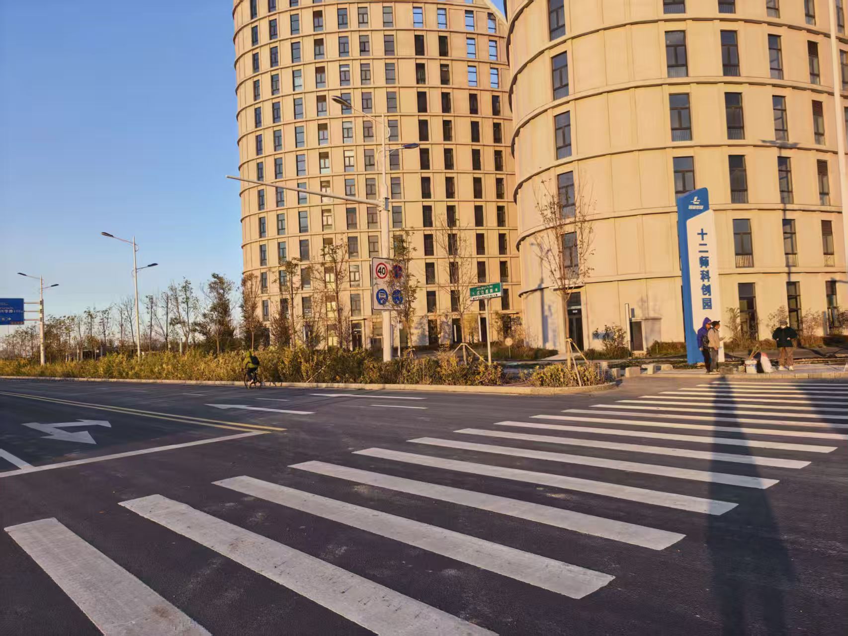 在十二师科创中心周边市政基础设施建设项目一标段,戍边西路(兴业街—安邦街)居民在路边等车。 冯晓玲摄.jpg