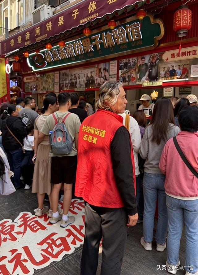 志愿者徐先生引导游客斜向排队