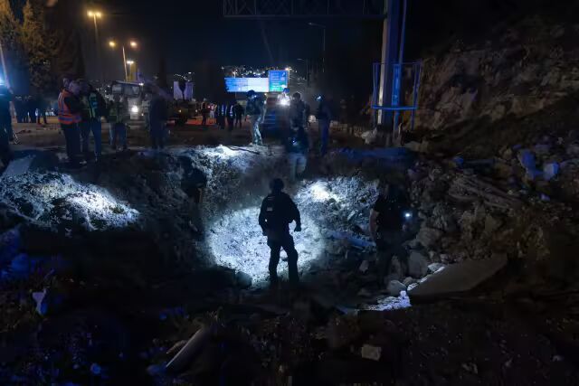 弥留解救东说念主员周日在耶路撒冷拉马特&middot;施洛莫社区进口隔壁查验伊朗导弹留传住的撞击坑。