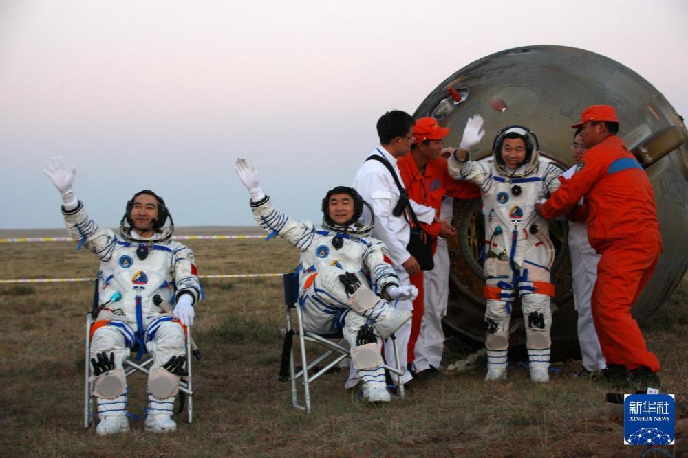 2008年9月28日，神舟七号返回地球，航天员翟志刚、刘伯明、景海鹏（从左至右）自主出舱后向现场搜救人员挥手致意。 新华社记者 王建民 摄