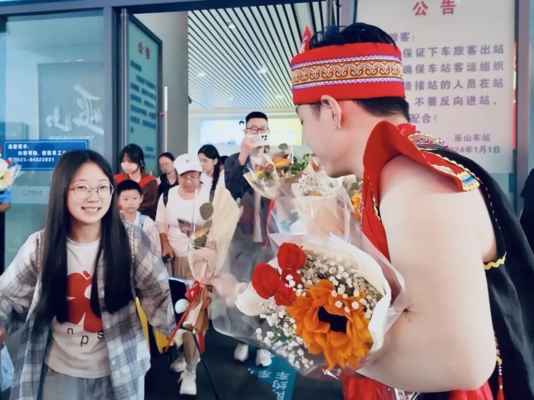 身着民族服饰的舞蹈演员们为旅客送上花束.JPG