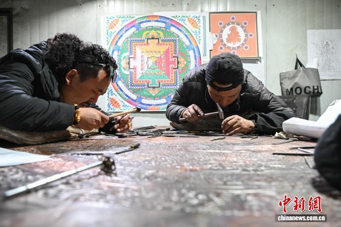 图为西藏雪堆白技工学校金属技艺教师罗布顿珠(左)，正带领弟子围坐在一起，专注进行金属锻造实操。贡嘎来松 摄