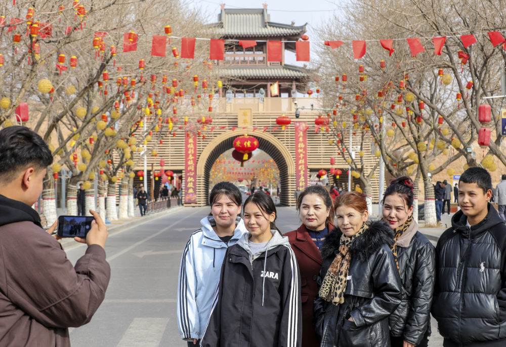 在新疆库车城门楼前，欢聚的一家人正在合影留念。新华社发（卜登鹏 摄）