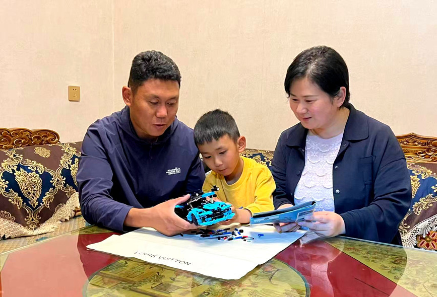 贾珂珂与丈夫罗布次仁陪伴着儿子,一家人围坐在桌前共同拼装模型。受访者供图