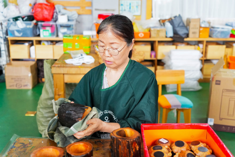 2026年5月12日，伊春永达工艺品有限公司员工正在擦拭制作好的松木工艺品。新华社记者 王祚 摄