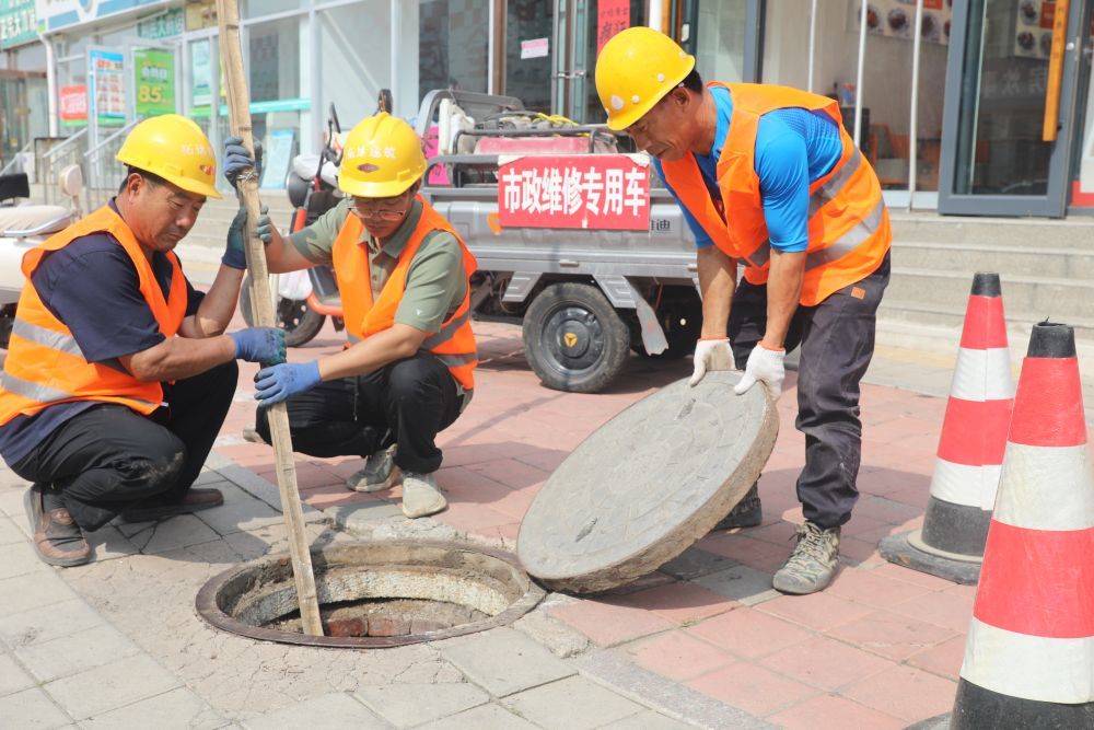河北承德平泉市政维修处工作人员正在对易发生内涝的老城区主街排水管道疏通维护。（李平文 摄）