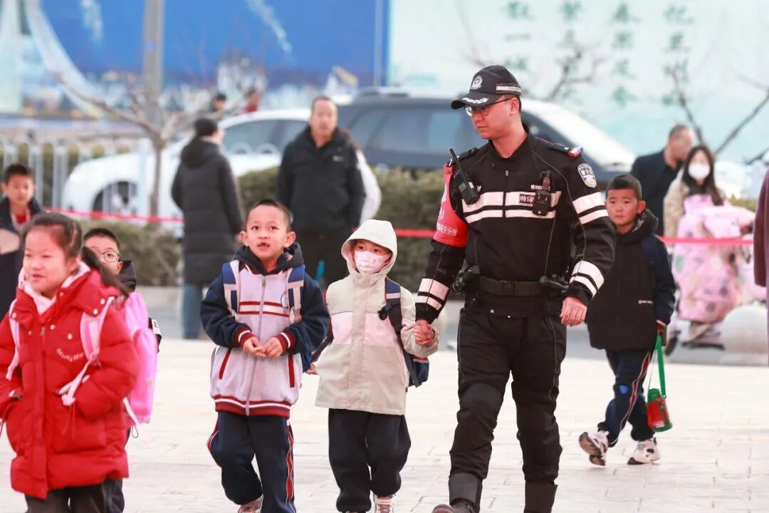 甘肃兰州，学生们和护学岗民警一起走进校园。图/中新图片