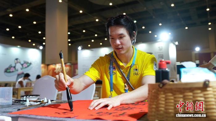 泰国代表团随队医生素帕塔(SUPATAT)体验中国书法。　陈英清 摄