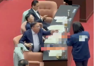 王义川拿水杯大力敲桌子。图源:台媒报道视频截图