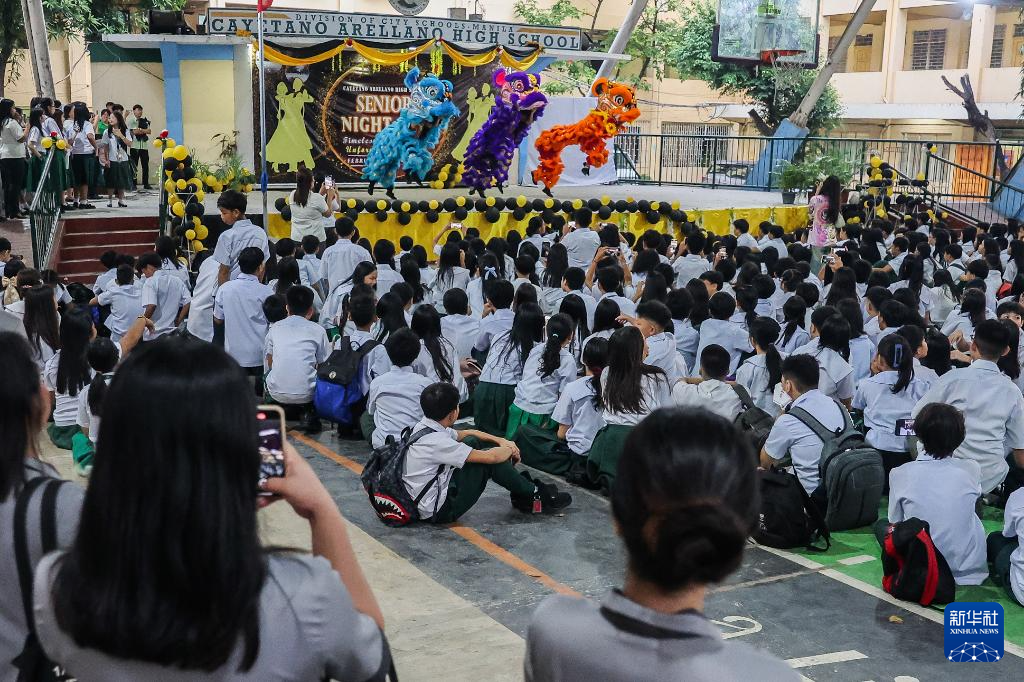 2月16日,在菲律宾马尼拉卡亚塔诺·阿雷利亚诺中学,学生们观看舞狮表演。 新华社发(乌马利摄)
