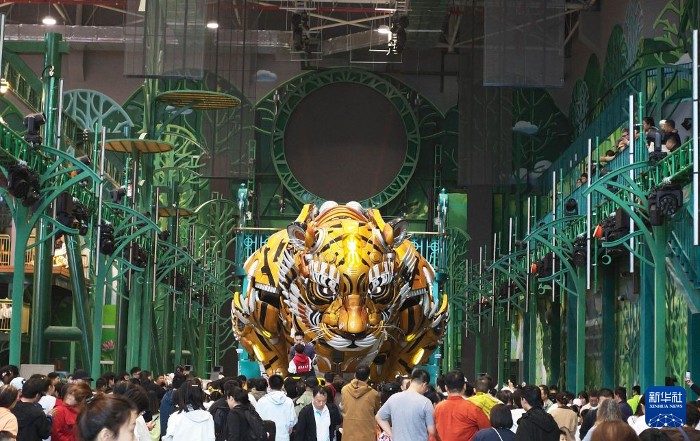 10月1日,在沈阳虎啸街文商旅综合体,游客观看机械巨兽“巨虎东东”表演。新华社记者 李钢 摄