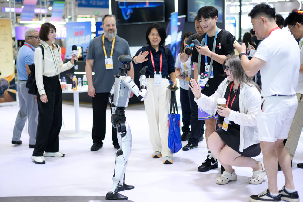 ↑ 4月14日，观众在第六届消博会科技消费展区与宇树机器人互动。新华社记者 辛悦卫 摄