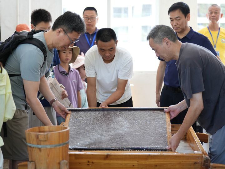 7月31日,游客在泾县中国宣纸小镇内体验宣纸制作。新华社发