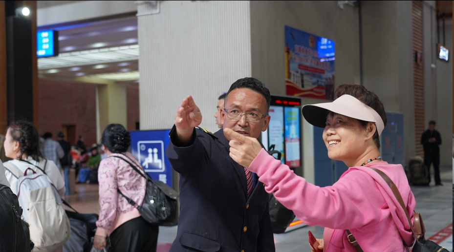 图为益西塔杰正在解答旅客问询。记者 康洁白姆 卢文静 摄