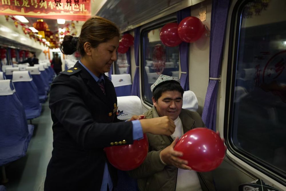 临近春节，列车工作人员与旅客共同布置车厢。新华社记者 白志强 摄