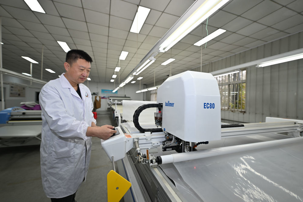 工人在天津纺织集团（控股）有限公司智能化生产车间内操作自动切布机。新华社记者孙凡越 摄