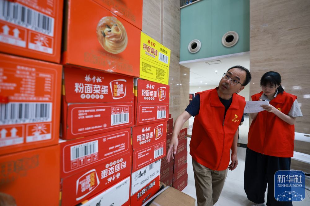↑ 7月11日,志愿者在浙江省乐清市城东街道安置点内清点储存物资数量。新华社记者 江汉 摄