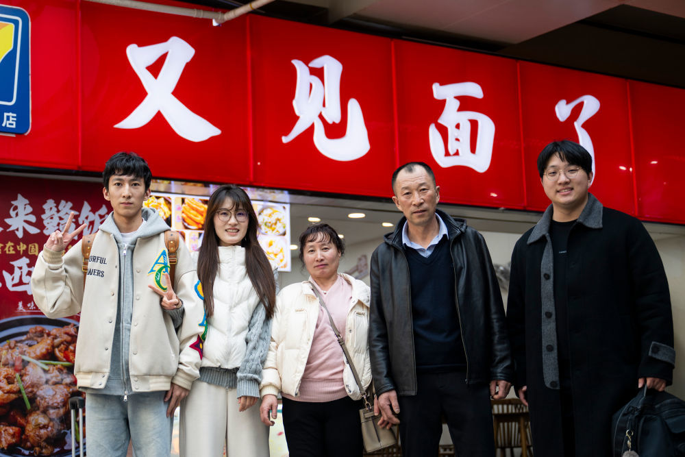 2月14日,在湖北武昌站,王女士(左二)与家人合影。今年王女士的父母和弟弟第一次从吉林珲春来武汉过年。新华社记者 伍志尊 摄