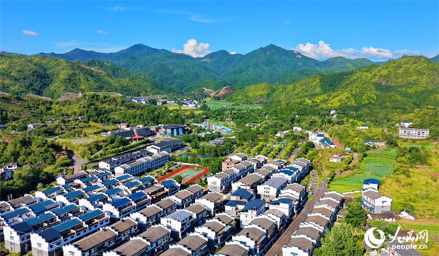 石城县琴江镇大畲村，一栋栋民居错落分布于青山田园间，与丹霞峰峦、青翠沃野相互映衬。人民网记者 朱海鹏摄