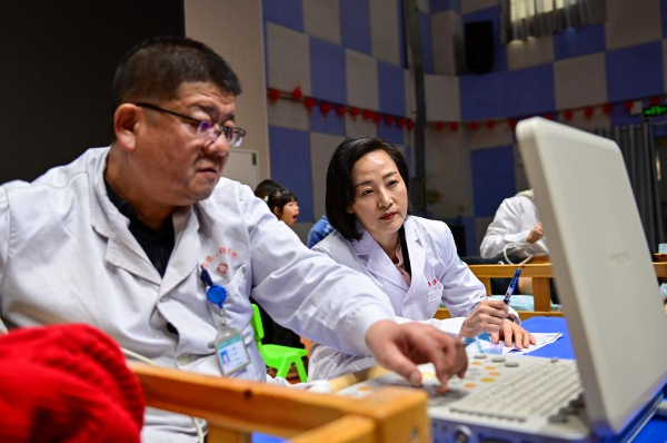 在新疆生产建设兵团第一师医院，吴玲燕（右）和同事在手术室探讨手术方案（2024年12月25日摄）。新华社记者 丁磊 摄