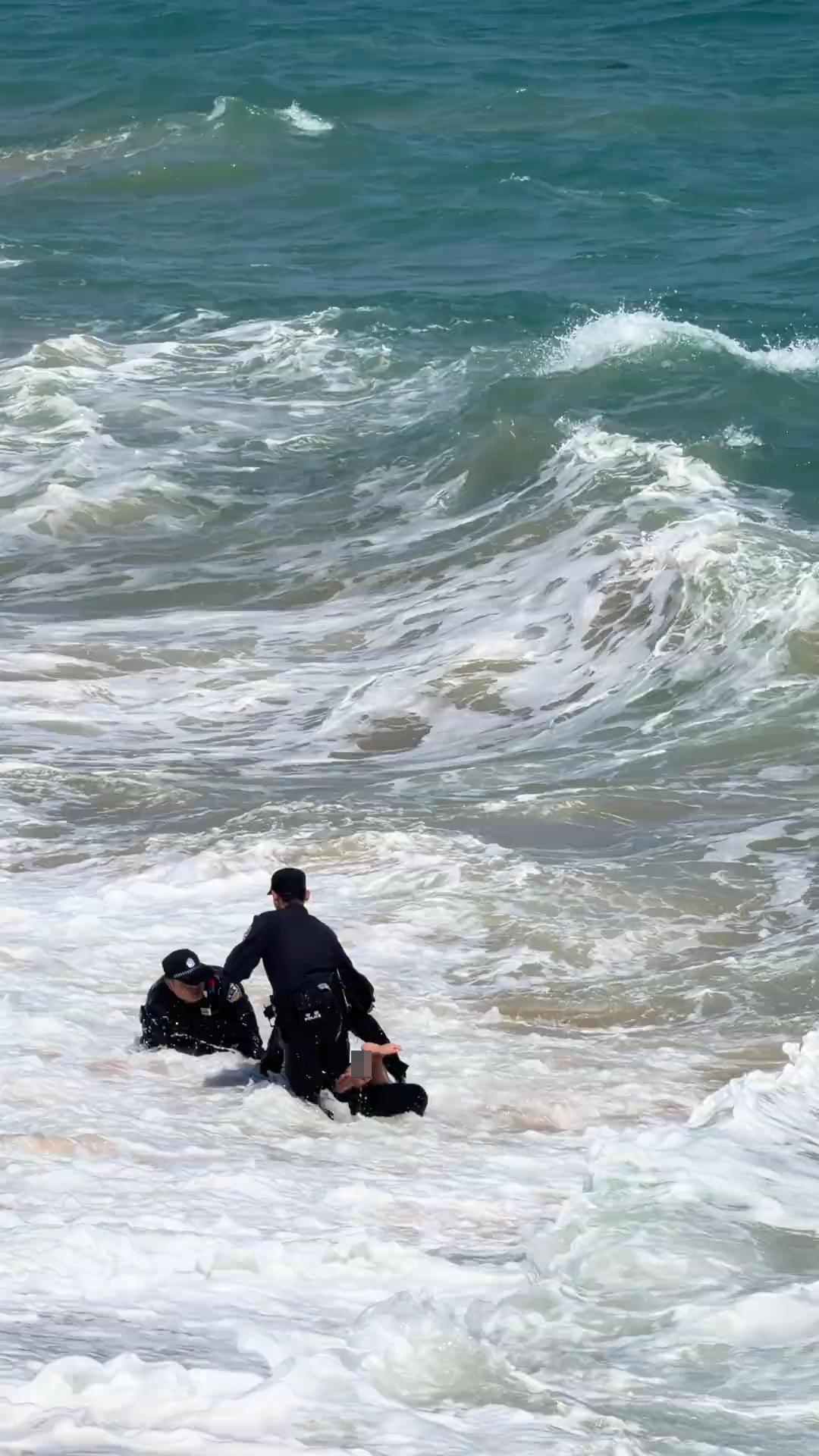 ▲民警在水中将落水的游客拉住