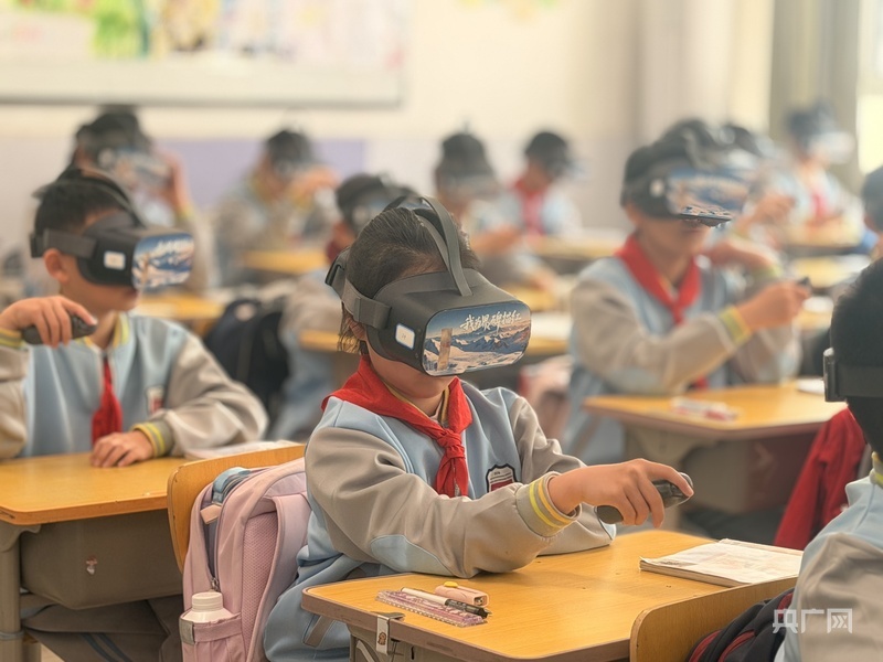 学生们头戴VR眼镜为界碑描红（央广网记者 褚夫晴 摄）