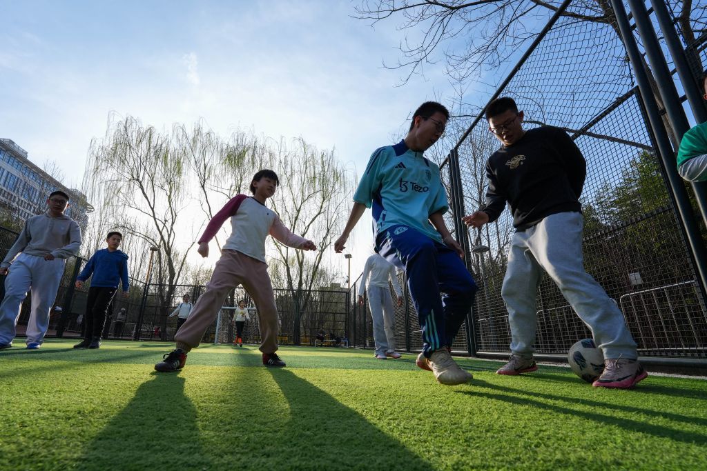 3月22日,市民在北京市西城区北营房城市森林公园内的免费足球场踢球。新华社记者 谢晗 摄